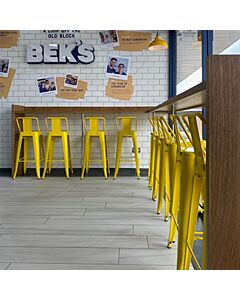 Profile view of Yellow Tolix Bar Height Stool Low Back