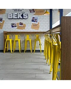 Profile view of Yellow Tolix Bar Height Stool Low Back